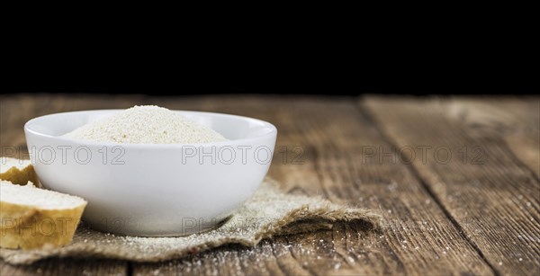 Some Bread Crumbs on a vintage wooden table (selective focus, close-up shot)