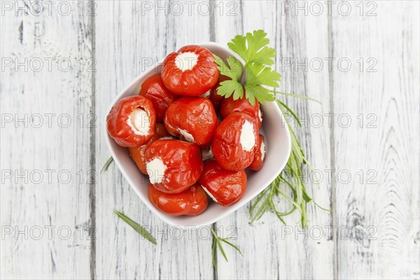 Fresh made Red Pepper (stuffed with cheese) on an old and rustic wooden table (selective focus,