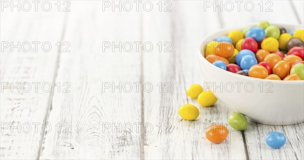 Cocolate coated Peanuts on a vintage background as detailed close-up shot (selective focus)