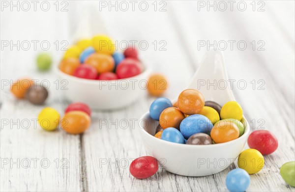 Fresh made Cocolate coated Peanuts on a vintage background (close-up shot)