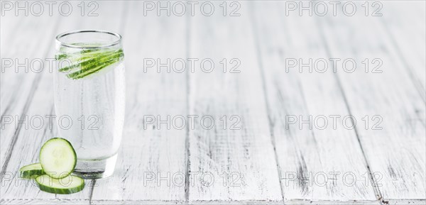 Cucumber Water on rustic wooden background as close-up shot