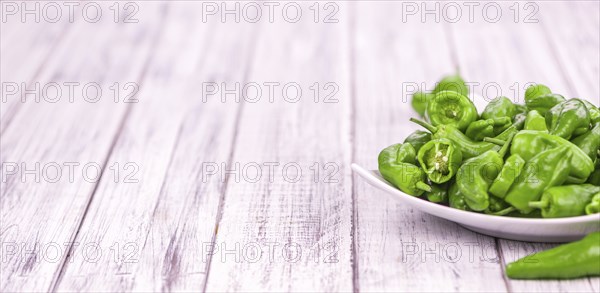 Raw Pimientos on rustic wooden background as close-up shot