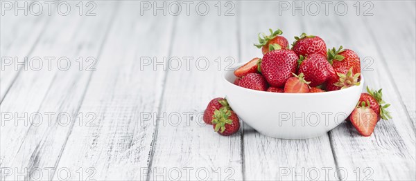 Strawberries as high detailed close-up shot on a vintage wooden table, selective focus