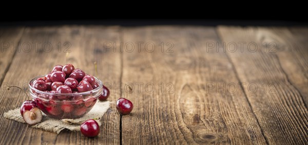 Canned Cherries as high detailed close-up shot on a vintage wooden table, selective focus