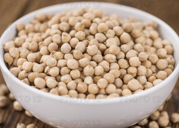 Dried Chickpeas as high detailed close-up shot on a vintage wooden table, selective focus