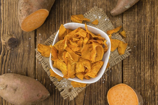 Sweet Potato Chips on a vintage background as detailed close-up shot, selective focus