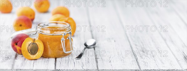 Apricot Jam on an old wooden table as detailed close-up shot (selective focus)
