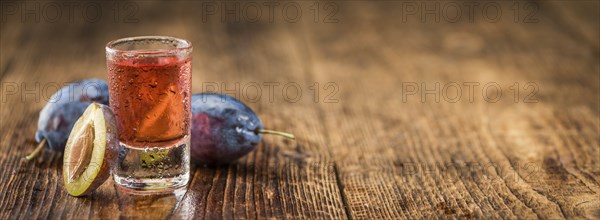 Plum Liqueur on a vintage background as detailed close-up shot, selective focus
