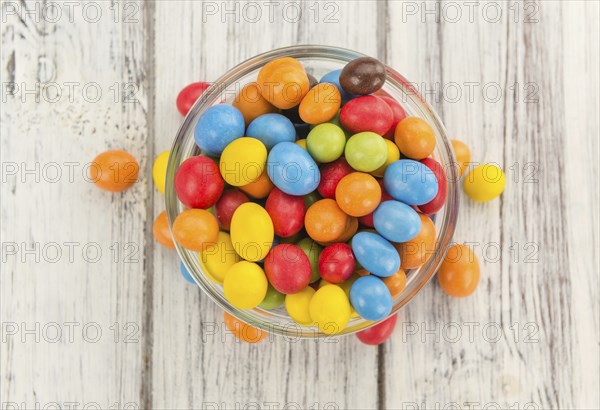 Fresh made Cocolate coated Peanuts on a vintage background (close-up shot)