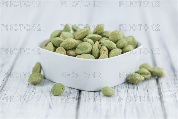 Wasabi Peanuts on a vintage background as detailed close-up shot (selective focus)