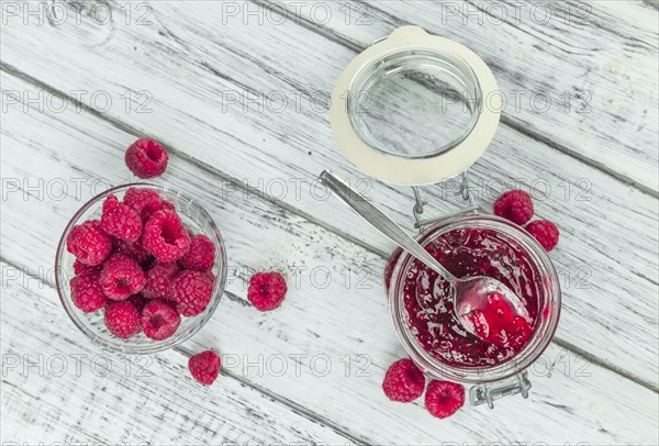 Fresh made Raspberry Jam on an old and rustic wooden table, selective focus, close-up shot