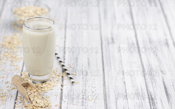 Healthy Oat Milk on a wooden table as detailed close-up shot (selective focus)