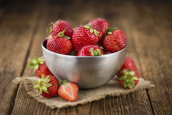 Strawberries on an old wooden table as detailed close-up shot, selective focus