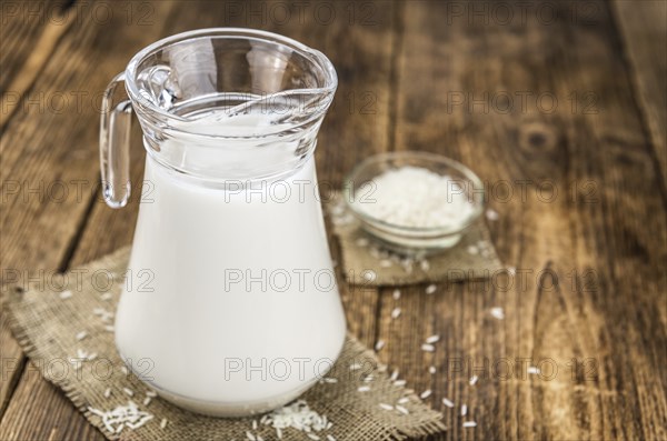 Wooden table with Rice Milk (detailed close-up shot, selective focus)
