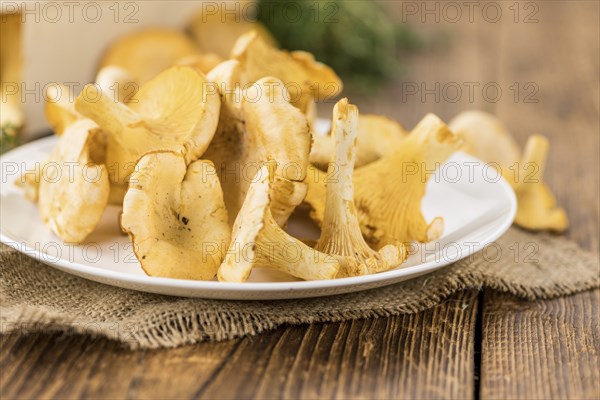 Portion of fresh harvested Chanterelles on wooden background as detailed close-up shot (selective