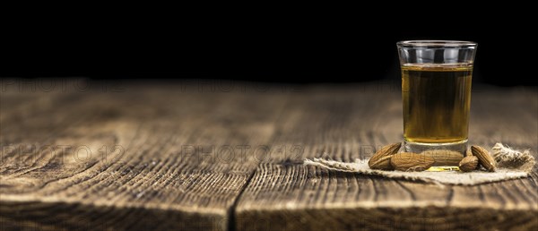 Amaretto on an old wooden table (selective focus)