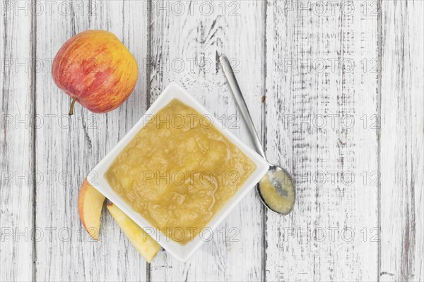 Homemade Applesauce (selective focus, close-up shot) on vintage background with some fresh fruits