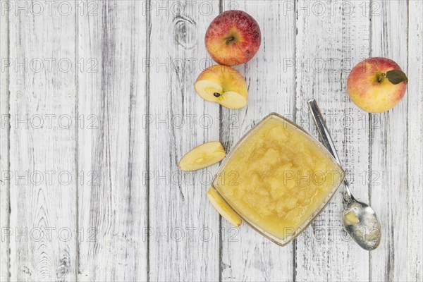 Old wooden table with fresh made Applesauce (selective focus, close-up shot)