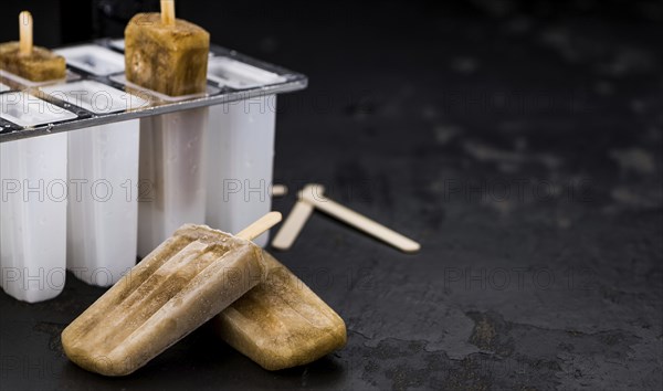 Some homemade Cola Popsicles (close-up shot, selective focus) on vintage background