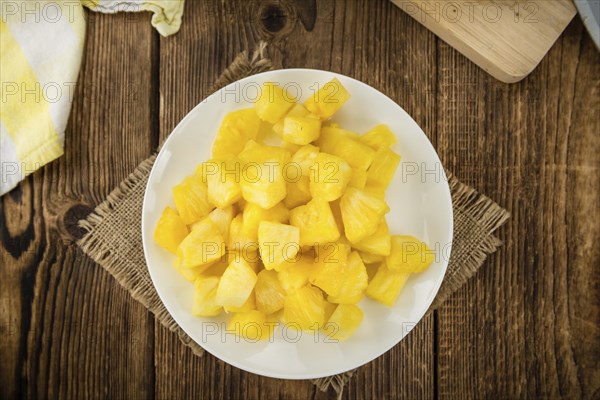 Sliced Pineapple on an old wooden table as detailed close-up shot, selective focus