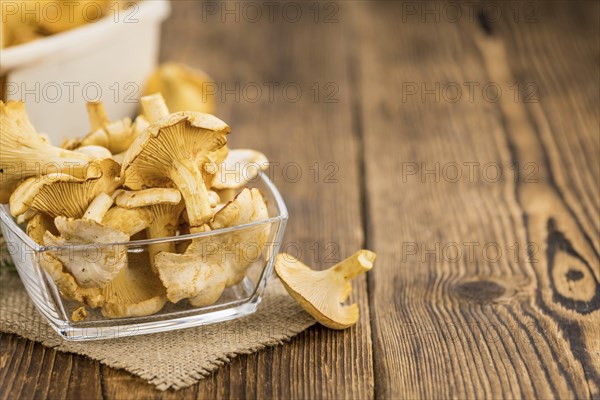 Chanterelles (freshly harvested) on an old wooden table as detailed close-up shot (selective focus)