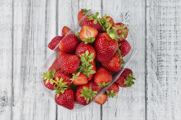 Strawberries as high detailed close-up shot on a vintage wooden table, selective focus