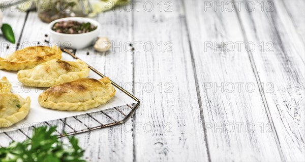 Portion of healthy Empanadas on an old wooden table (selective focus, close-up shot)