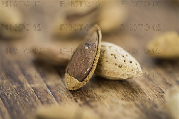 Almonds in shell (roasted and salted) on a vintage background (close-up shot)
