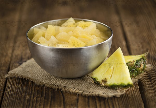 Preserved Pineapple pieces on a vintage background as detailed close-up shot, selective focus