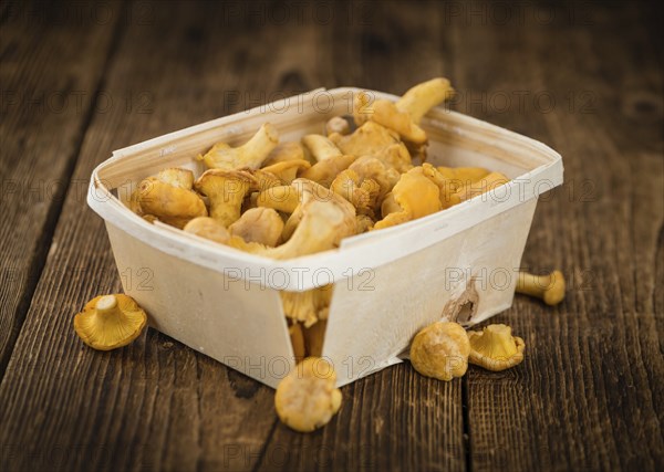 Chanterelles as high detailed close-up shot on a vintage wooden table, selective focus