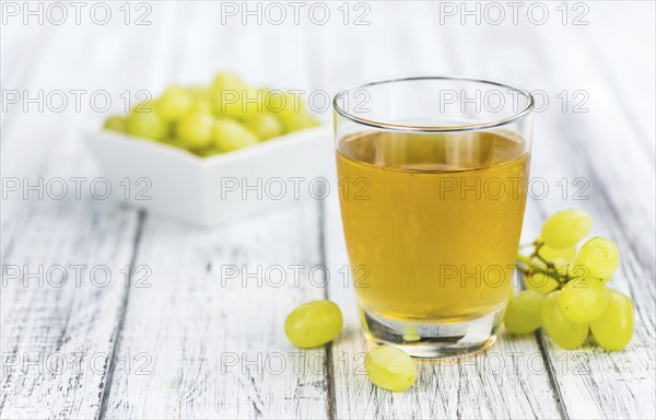 Wooden table with Grape Juice (detailed close-up shot, selective focus)