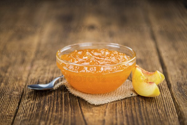 Homemade Peach Jam on an wooden table as detailed close-up shot, selective focus