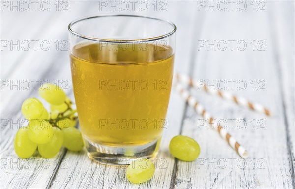 Wooden table with Grape Juice (detailed close-up shot, selective focus)