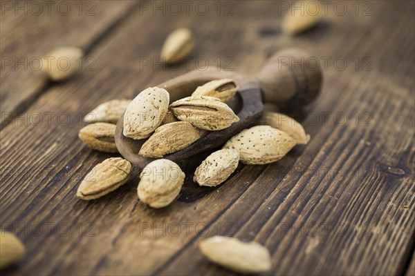 Roasted and salted Almonds (with shell) on a vintage background (close-up shot)
