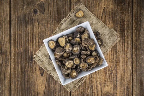 Fresh made Shiitake mushrooms (dried) on an old and rustic wooden table, selective focus, close-up