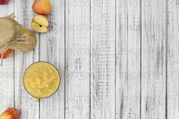 Old wooden table with fresh made Applesauce (selective focus, close-up shot)
