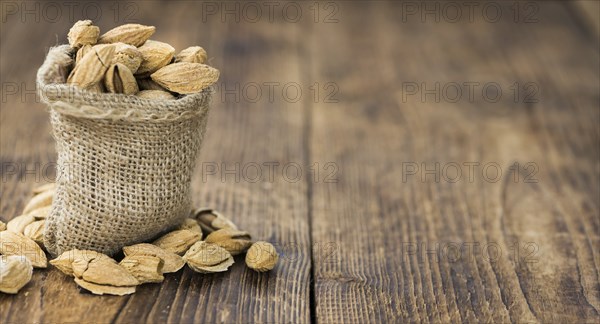 Roasted and salted Almonds (with shell) on a vintage background (close-up shot)