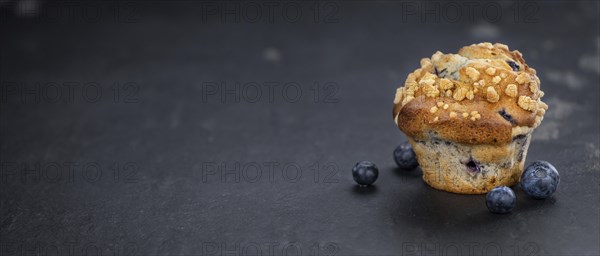 Portion of healthy Blueberry Muffins on a slate slab (selective focus)