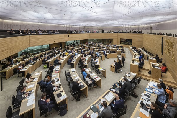 State parliament of Baden-Württemberg, plenum with state coat of arms and gallery with visitors.