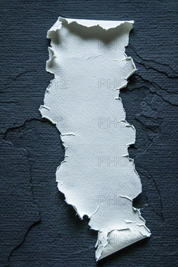 A piece of torn paper with ripped edges placed on a dark background, creating a strong contrast, AI