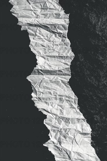 Crumpled paper creating a curved path with strong contrast between black and white, evoking texture