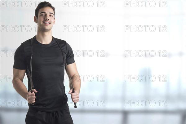 Fit athlete jumping rope, in a gym