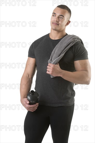 Man holding a protein shake after a workout in the gym, isolated in white