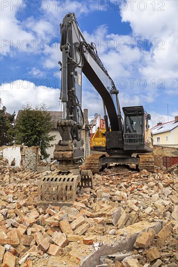 Excavator on the rubble of a demolished building