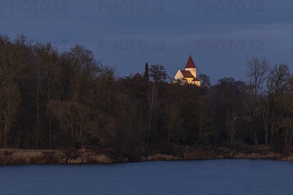 Illuminated church of Schaefstall near Donauworth above a lake in Bavaria