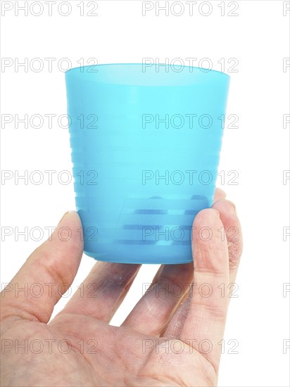 Empty blue plastic glass, held in a male persons hand
