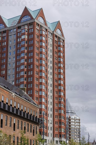 Tall modern residential building with red and grey facades and glass elements, rotterdam, the