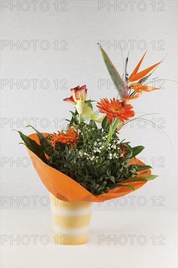 A bouquet of roses, carnations and orchids in a vase