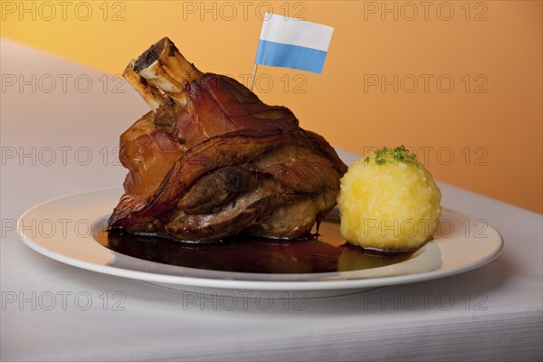 Pork knuckle with potato dumplings on a plate