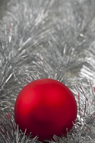 Red Christmas bauble on silver tinsel